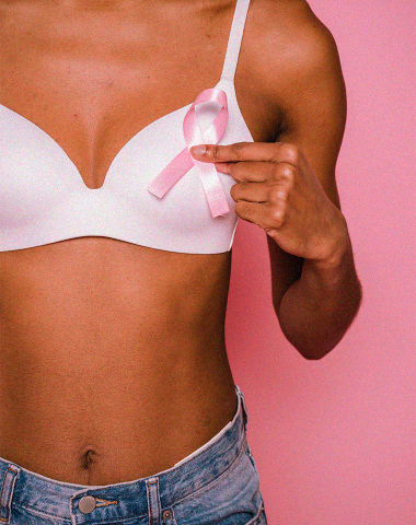 mulher com câncer de mama segurando símbolo da campanha