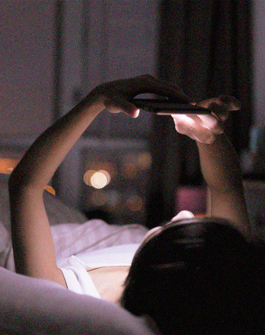 mulher segurando celular a noite